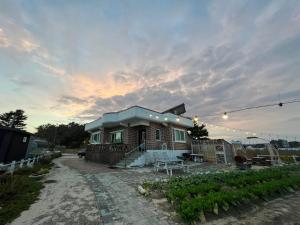 a small house with a table in front of it at Gangneung Mediterranean Pension in Gangneung