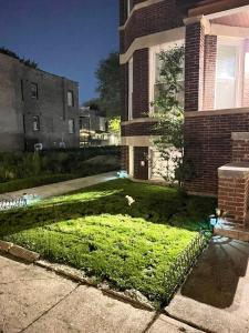 une cour herbeuse devant une maison en briques dans l'établissement Simplified Living Space, à Chicago