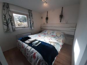 a small bedroom with a bed and a window at Chalet Esdoorn in Putten, Gezellig en Luxe gerenoveerd in Putten