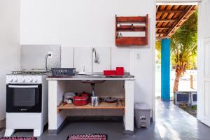 a kitchen with a counter and a sink and a stove at Pousada Vila Rosa - Caraiva in Caraíva +139 photos