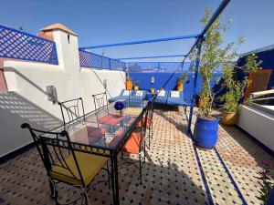 a balcony with a table and chairs on a roof at Riad Villa El Arsa in Marrakech