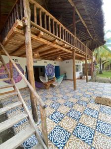 a patio with a tile floor and a wooden roof at Playa Jaguar - Beach Club in Moñitos +70 photos