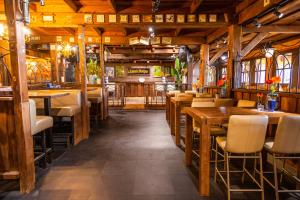 un restaurante con suelo de madera, mesas y sillas en EuroParcs De IJssel Eilanden, en Kampen
