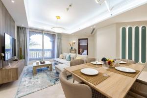 sala de estar con mesa de comedor y sofá en Luxury 1Bedroom on Private Beach Residence at Palm, en Dubái