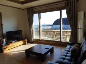 a living room with a couch and a table at Gangneung Mediterranean Pension in Gangneung