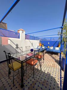 Riad Villa El Arsa في مراكش: فناء على طاولة وكراسي على شرفة