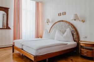 a bedroom with a large bed with white sheets and pillows at Hotel Hammer in Weiz