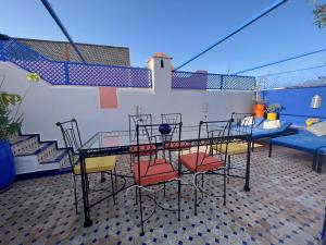 un patio con mesa, sillas y escaleras en Riad Villa El Arsa, en Marrakech