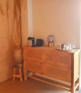 un comò in legno in una stanza con un vaso di B&B Mooi Montferland a Zeddam