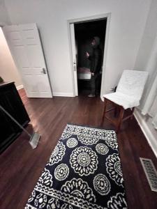 a man standing in the doorway of a room with a rug at Simplified Living Space in Chicago