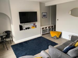 a living room with a couch and a flat screen tv at Seaview Aurora House - Central Luxury Apartment in Warrenpoint