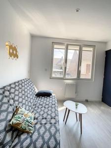 sala de estar con sofá y mesa en Cosy T2 Wifi Parking Proche gare CENTRE VILLE en Saint-Quentin