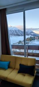 a couch sitting in front of a large window at Orcières Rond Point des Pistes 1 Panoramique, Front de Neige in Orcières +19 photos