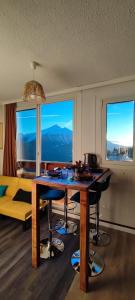 a living room with a table with chairs and windows at Orcières Rond Point des Pistes 1 Panoramique, Front de Neige in Orcières