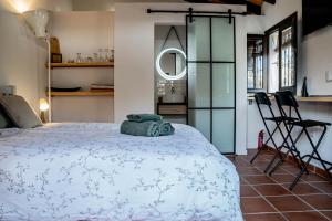 Finca Las Hierbas B&B في ألورا: غرفة نوم بسرير كبير ومطبخ