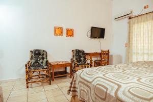 a bedroom with a bed and a table and chairs at Palo Rosa Lodge in Puerto Iguazú