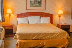 a hotel room with a bed with two nightstands and two lamps at Colfax Inn By Marifah in Colfax