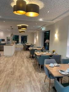 a restaurant with tables and chairs and a kitchen at Ferienhof Pankalla in Neubruchhausen