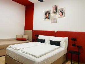 um quarto com uma cama com uma cabeceira vermelha e fotografias na parede em House of Bruno - Only self check-in em Trento