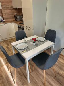 ソフィアにあるCloud 9 Apartment by LMGの白いテーブル(椅子、皿、グラス付)