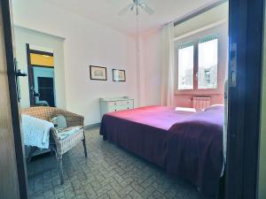 een slaapkamer met een bed, een stoel en een raam bij La Casa Di Wilde in Lerici