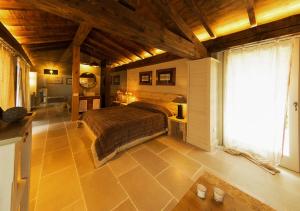 sypialnia z łóżkiem i dużym oknem w obiekcie Colletto AgriBioRelais w mieście Villongo SantʼAlessandro