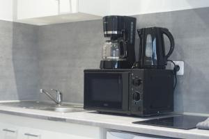 um balcão de cozinha com comodidades para preparar café em cima de um micro-ondas em Coquet STUDIO TOUT ÉQUIPÉ CENTRE VILLE WIFI 2PERS em Saint-Quentin