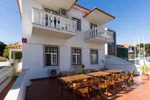 eine Terrasse mit einem Tisch und Stühlen auf einem Gebäude in der Unterkunft Eco Ljmonade Hostel in Cascais