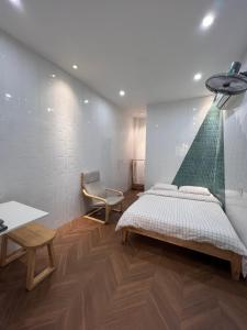 een slaapkamer met een bed, een tafel en een stoel bij Meow Hotel & Cafe in Ho Chi Minh-stad