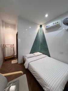 twee bedden in een kamer met een driehoek aan de muur bij Meow Hotel & Cafe in Ho Chi Minh-stad