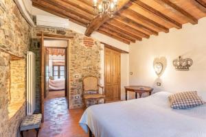 a bedroom with a bed in a room with a stone wall at Villa Pera by Nicola Real Estate in Corsanico-Bargecchia