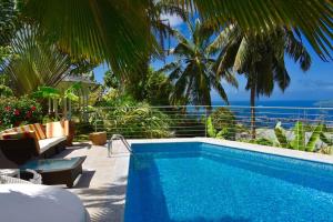 a swimming pool with a view of the ocean at Maison de Jardin Villa in Victoria