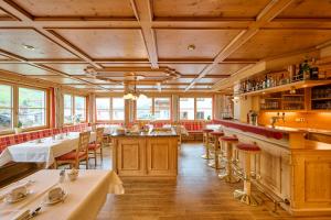 un restaurante con techos de madera, mesas y sillas en Hotel Bianca, en Lech am Arlberg