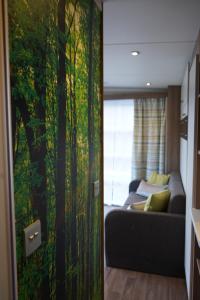 a living room with a couch and a painting of trees at Koie Smart in Stranda