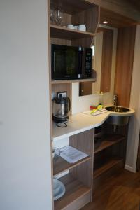 a kitchen with a counter with a microwave and a sink at Koie Smart in Stranda