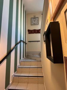 a hallway with stairs with green and white stripes at Casa Aida in Mezzago
