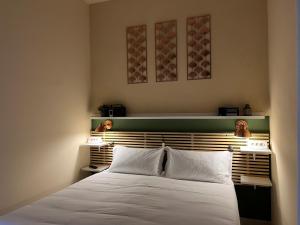 una camera da letto con un grande letto bianco con due lampade di CASA AIDA B&B by Opera House 