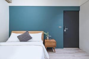 a bedroom with a bed and a blue wall at Lin Suites by Olala Homes in Taipei