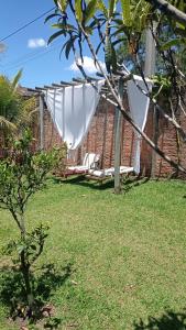 a white hammock in a yard with a building at Estúdio dentro de uma chácara em Botucatu rubiao jr in Botucatu