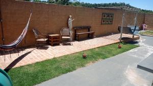a backyard with chairs and a hammock and a wall at Estúdio dentro de uma chácara em Botucatu rubiao jr in Botucatu