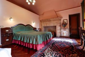 a bedroom with a large bed and a fireplace at Hotel Corte dei Tini in Teramo