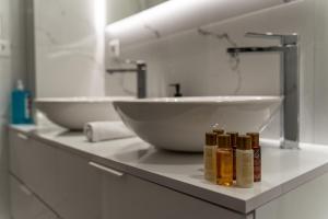 een badkamerbar met 2 wastafels en 2 flessen bij Harmony Sea View Apartment in Thessaloniki +57 foto's