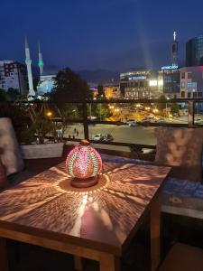 uma luz sobre uma mesa com vista para uma cidade em The Rooftop Hostel em Shkodër
