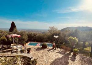 una persona in piedi accanto alla piscina di Villa Le Selvarelle by Nicola Real Estate a Corsanico-Bargecchia