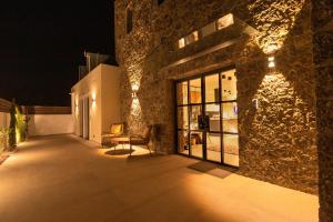 Arivallos Villa & SPA with Sauna and Wine Cellar في (( Litherés )): مبنى مع فناء في الليل مع أضواء