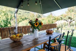 a wooden table with a vase of flowers and a basket of fruit at La Valle in Agerola