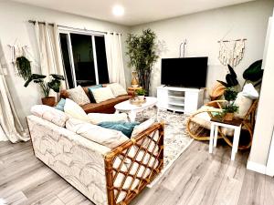 ein Wohnzimmer mit einem Sofa und einem TV in der Unterkunft Boho Hideaway in Sylvan Lake