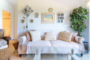 een woonkamer met een bank en een plant bij Costa Lago Playa in Torremolinos +24 foto's