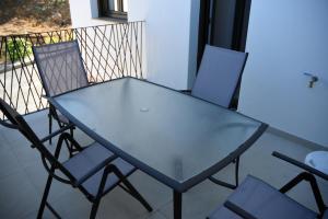 einen Glastisch und zwei Stühle auf dem Balkon in der Unterkunft APTOS MILLÁN in Ardales
