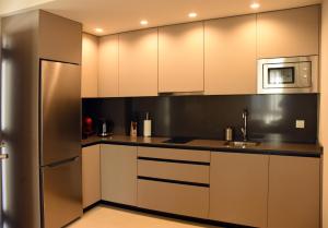 a kitchen with white cabinets and a stainless steel refrigerator at APTOS MILLÁN in Ardales